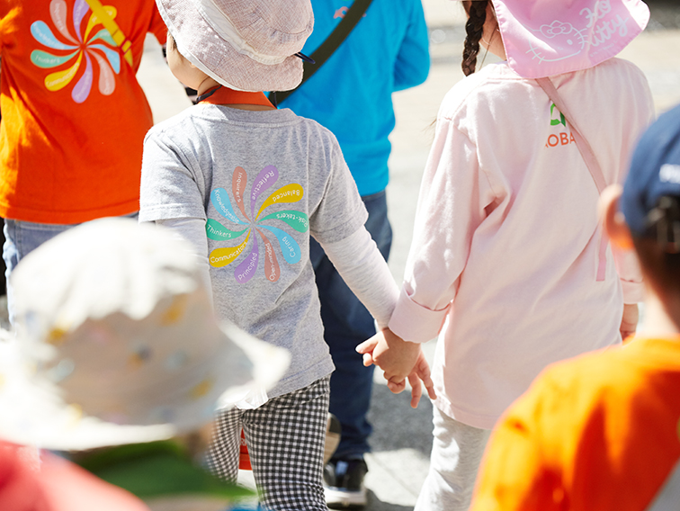 手を繋いで外を歩く子供たち